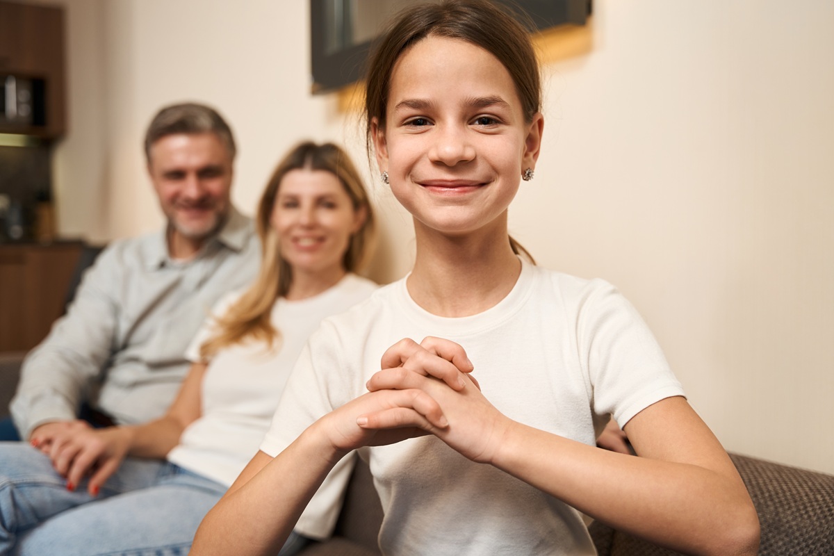 Smiling girl with her parents at home